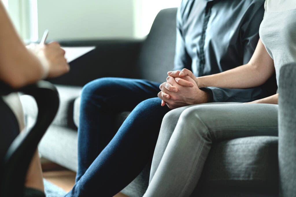 Counseling and therapy for couple and family. Adoption, psychology or psychotherapy concept. Session with psychiatrist or psychologist. Husband and wife with marriage counselor. Man, woman and doctor.